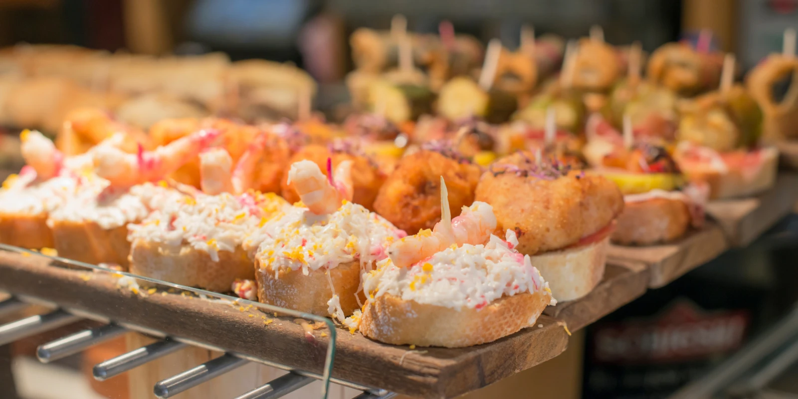 Pintxos and tapas lined up on the counter of a Madrid tapas bar